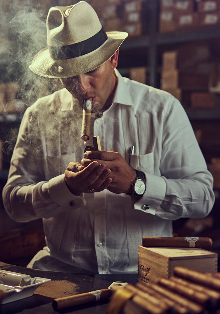 an image of a man lighting a Davidoff cigar