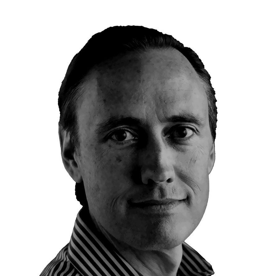 Steve Jurvetson A black and white portrait of a middle-aged Caucasian man with short hair. He is looking directly at the camera with a neutral expression. He is wearing a striped collared shirt, adding a touch of pattern to the monochrome image. The lighting is soft, creating subtle shadows that highlight his facial features.