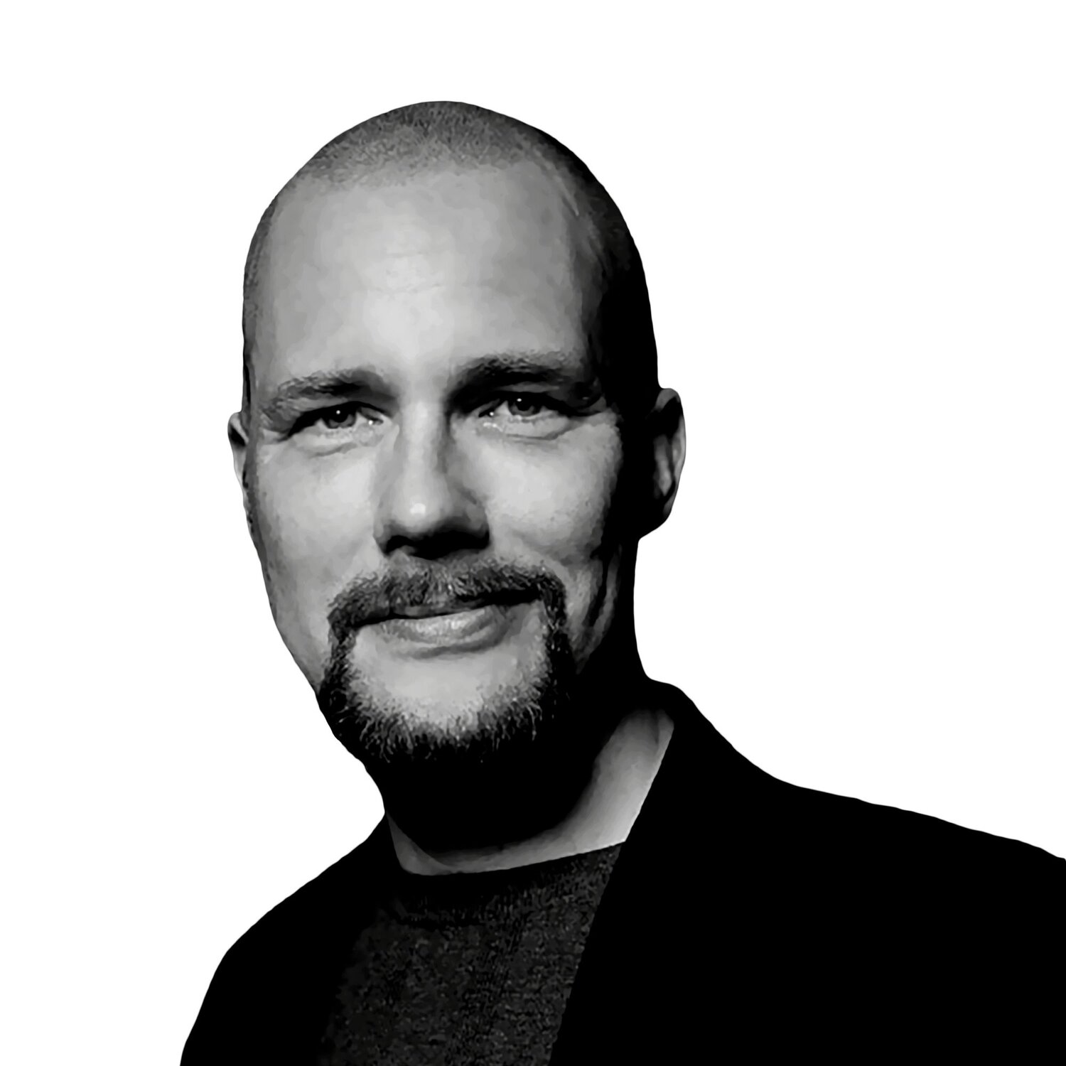 Jonas Andrulis Black and white portrait of a smiling man with a shaved head and a goatee, wearing a blazer, set against a plain background.