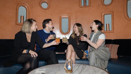 HumanX attendees smile and cheers one another at an afterparty event at the conference