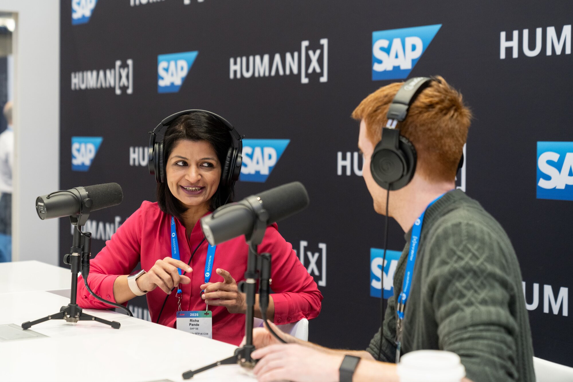 A view of two humanx attendees recording a podcast in the podcast booth at humanx 2025