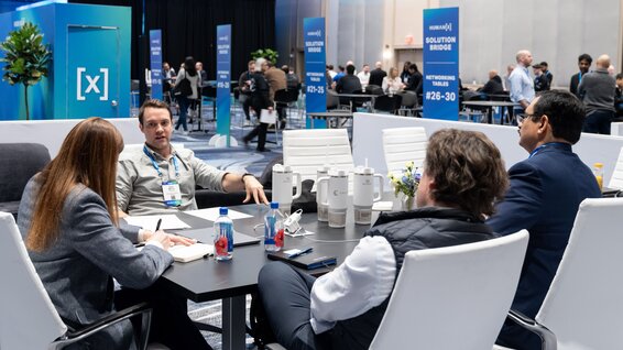 A networking meeting is happening in a private meeting space at the SolutionBridge floor at HumanX 2025