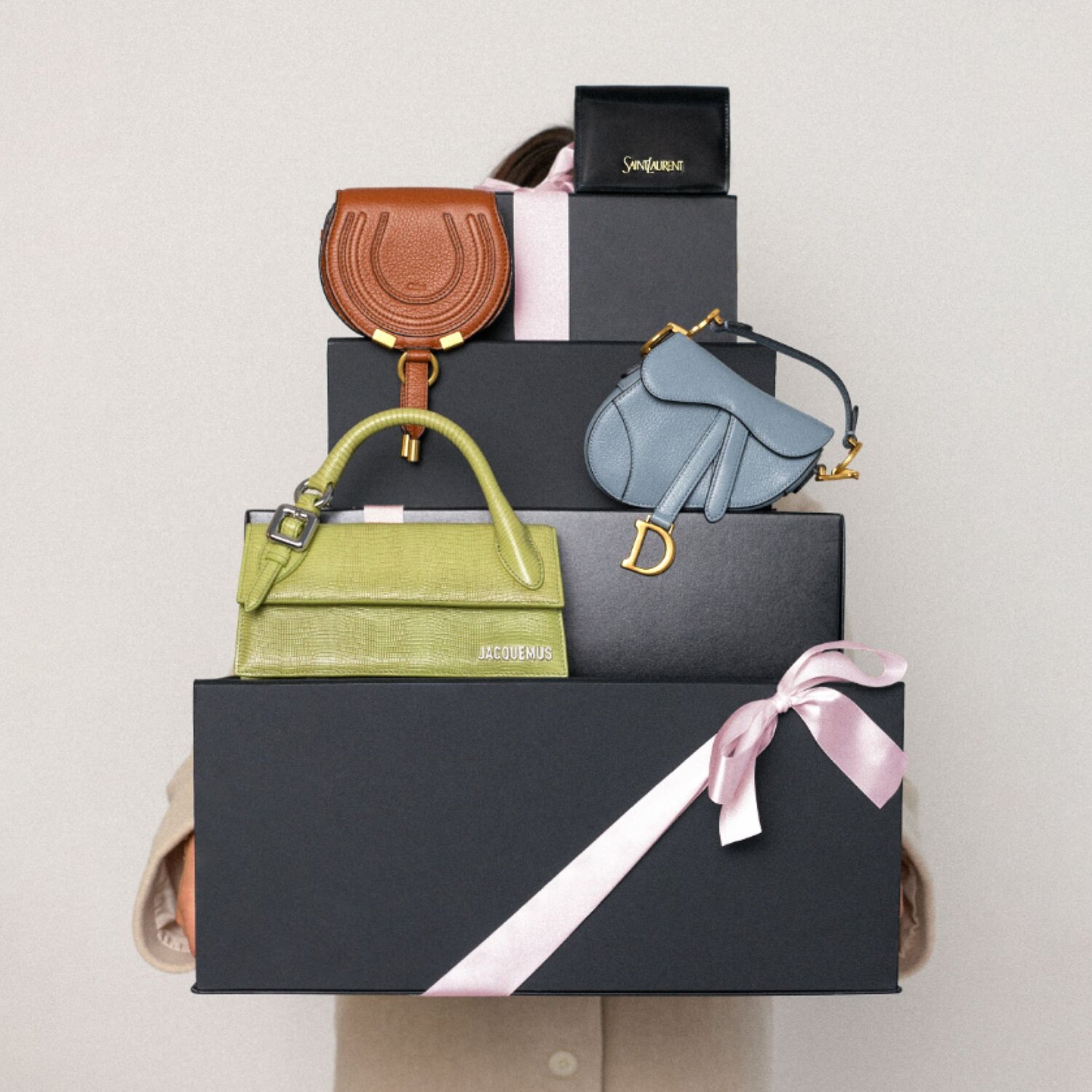 Woman holding holiday boxes and handbags from Vivrelle.