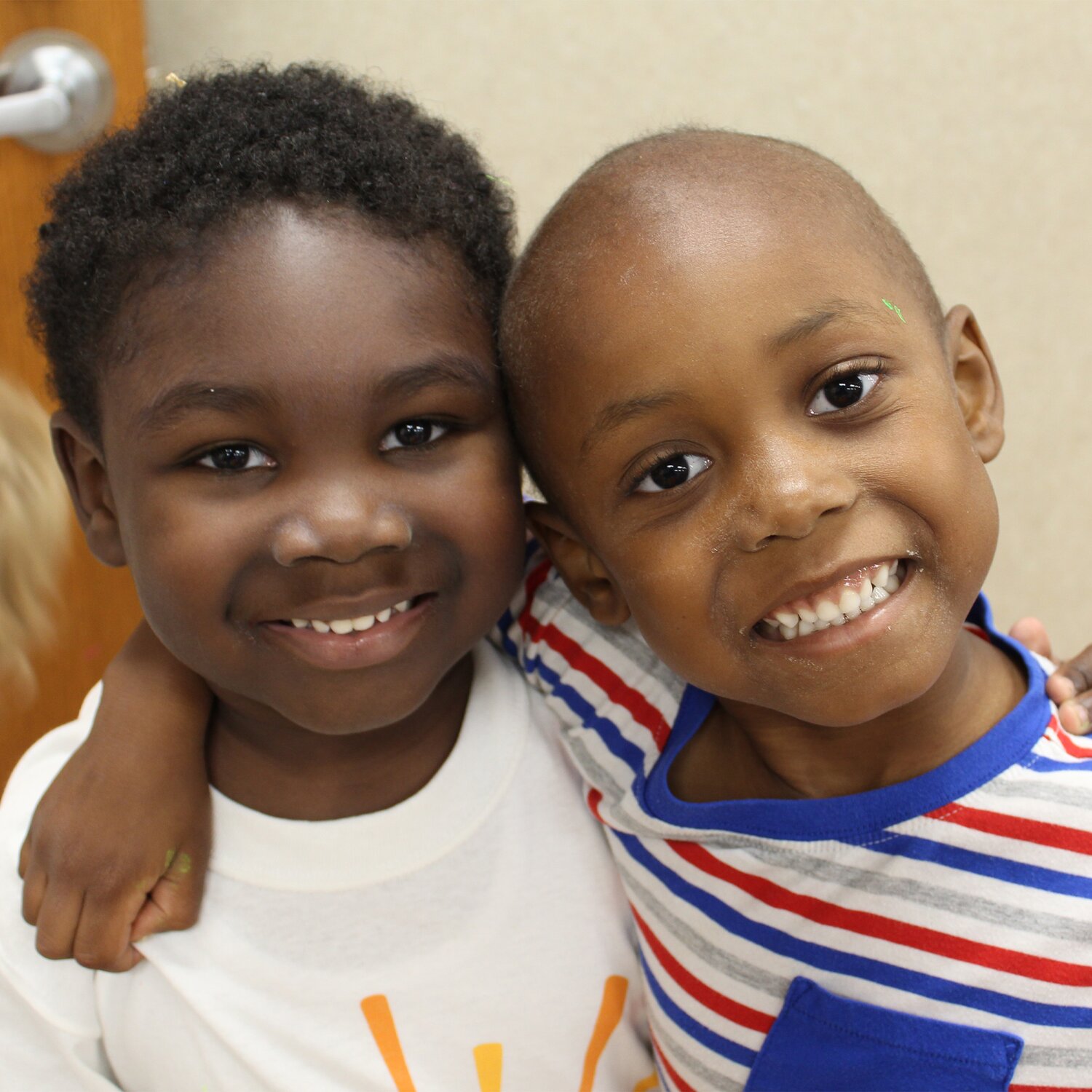 Two children hugging. Smiling at camera