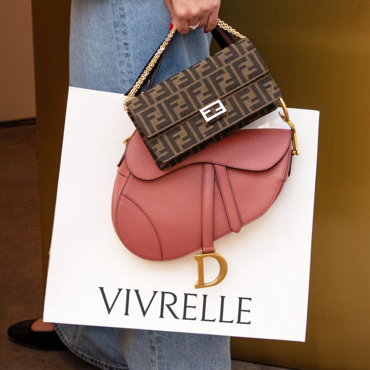 Woman carrying two luxury bags from Vivrelle from the Classique tier.