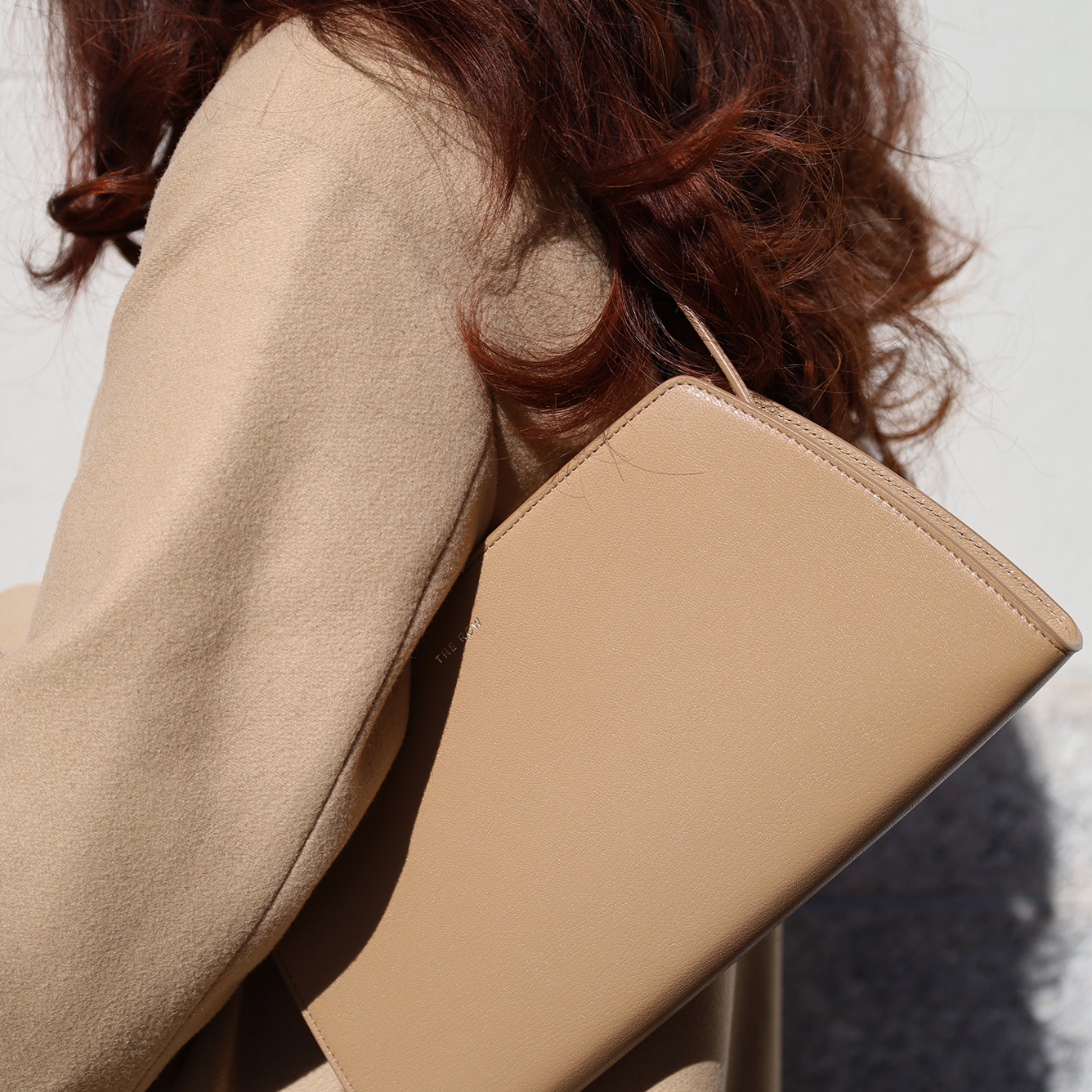 Image of a woman with a luxury The Row handbag from Vivrelle.