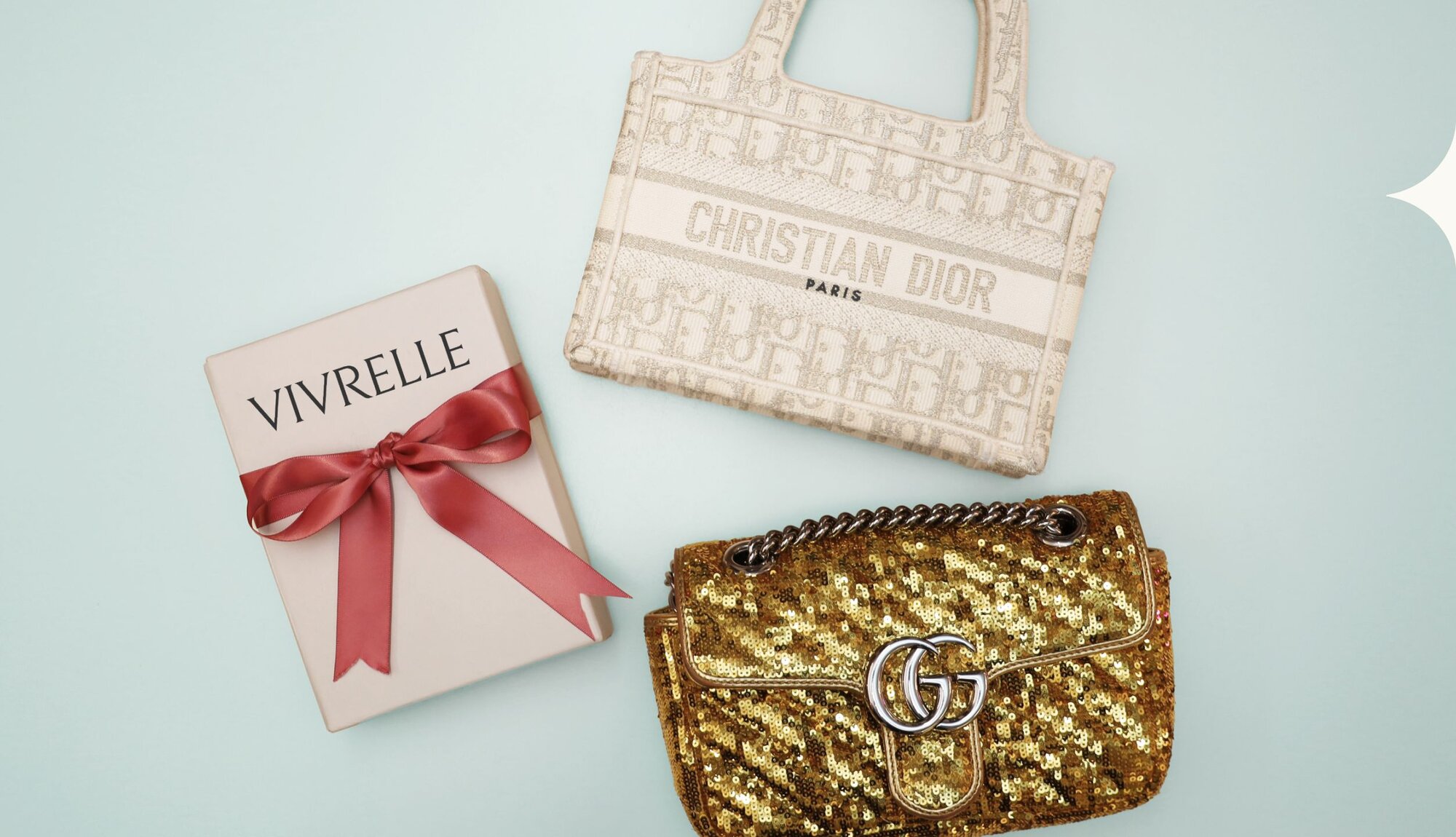 Gold and beige bags next to a Vivrelle gift wrapped in a bow