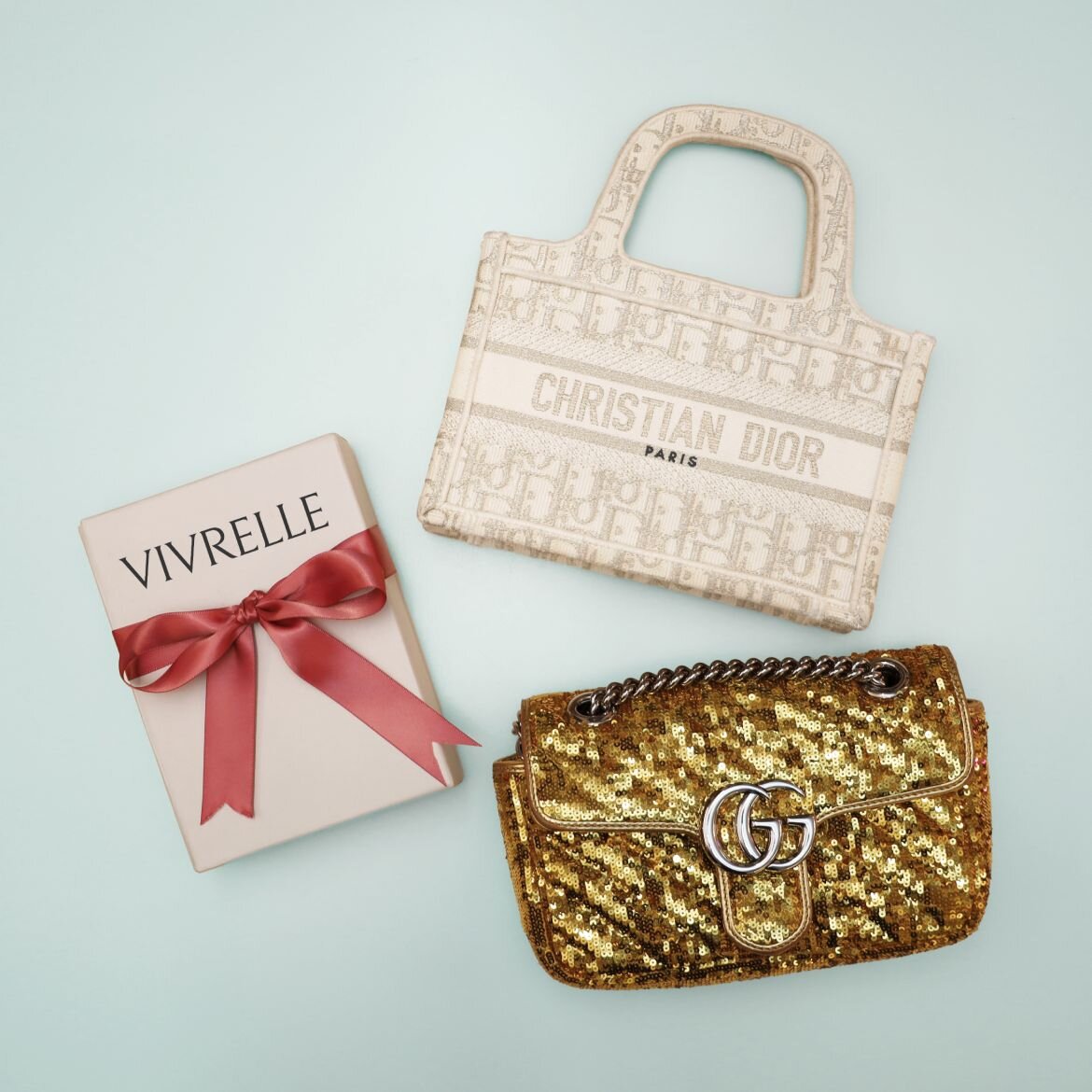 Gold and beige bags next to a Vivrelle gift wrapped in a bow