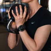 Femme en salle de sport vérifiant sa montre connectée. Montres en paiement mensuel avec Leasi.