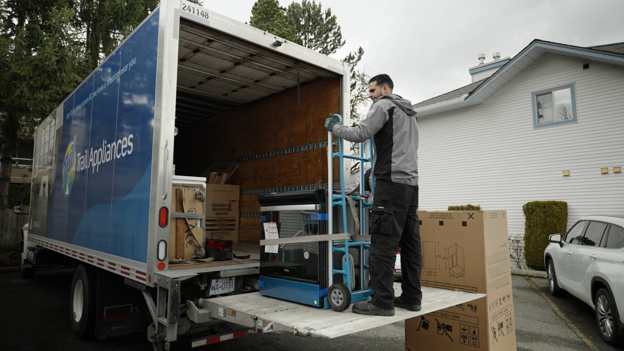 Trail Appliances delivery team unload a range from the truck.