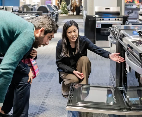 An appliances expert greeting customers in the Trail Appliances showroom