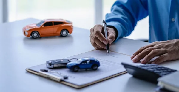 Vender um carro. Conceito de gestão. O revendedor dá as chaves do carro ao novo proprietário ou locatário com um contrato de seguro. Clientes que assinam o contrato e os termos do contrato do documento