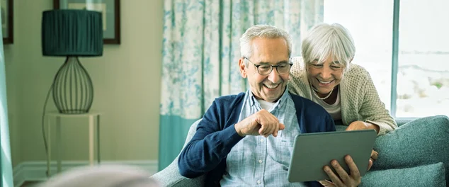 senhor e senhora olhando para tablet