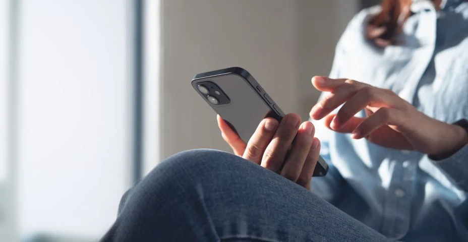 Mulher jovem usando o telefone celular para compras on-line via aplicativo móvel em casa. Mulher de negócios casual navegando na internet no smartphone durante o trabalho de casa, close up