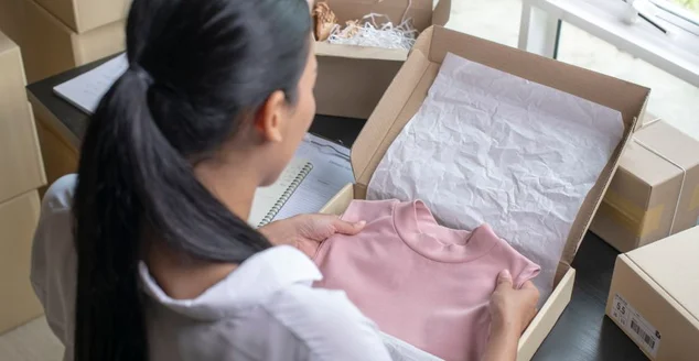 Mulher asiática e-commerce proprietário embalagem pacote caixa de correio preparando pacote de entrega na mesa.