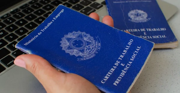 Tradução 'República Federativa do Brasil, Ministério do Trabalho'. Conceito de FGTS, desemprego, PIS, salário, aposentadoria, empregado e economia brasileira. Pasta de trabalho segurando a mão.