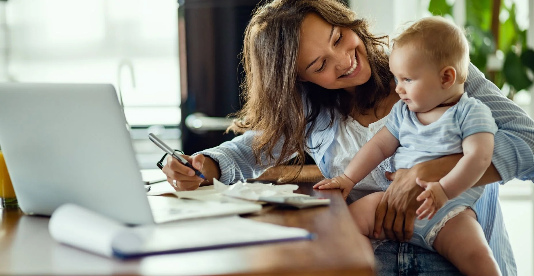 Mãe com sua filha e seu notebook para ilustrar artigo sobre reserva financeira para mães solo