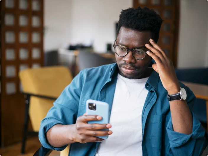 Homem preocupado e olhando para o celular