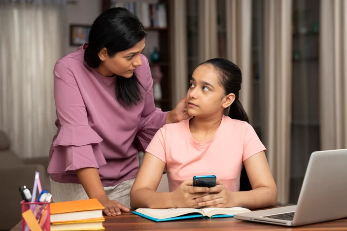 Mãe pega filha usando telefone enquanto estuda