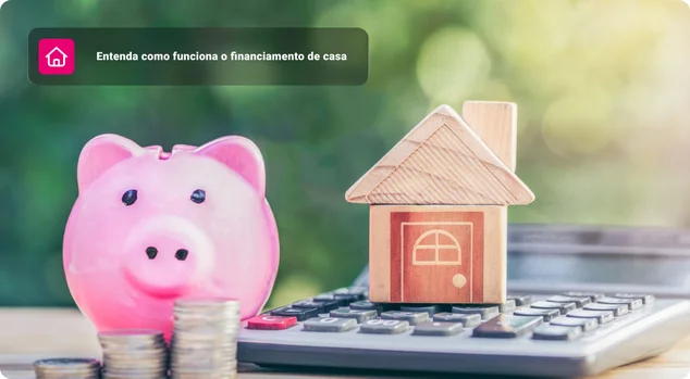 cofrinho rosa ao lado de moedas empilhadas e uma pequena casa de madeira sobre uma calculadora, simbolizando economia e planejamento para financiamento imobiliário.