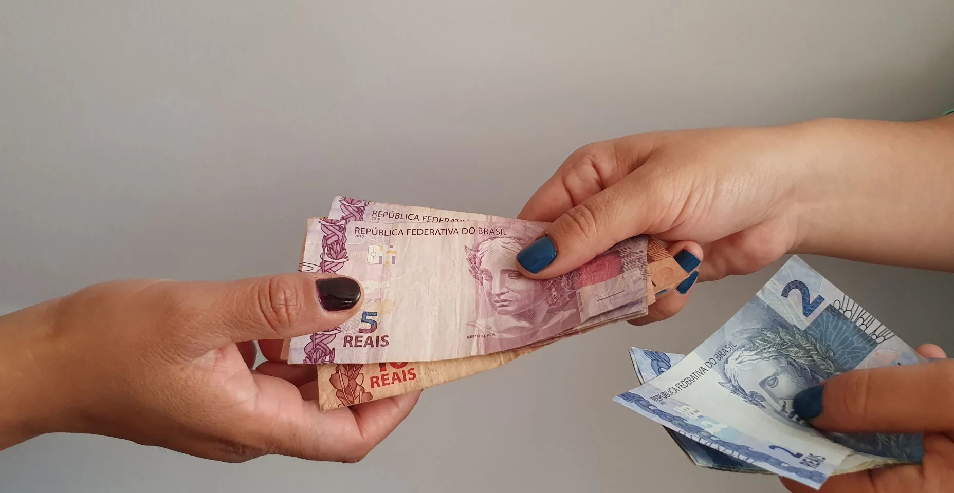 Mulheres mãos pagando e recebendo dinheiro brasileiro