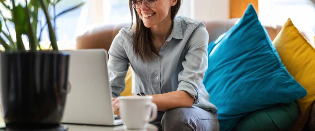 Jovem usando um laptop em casa