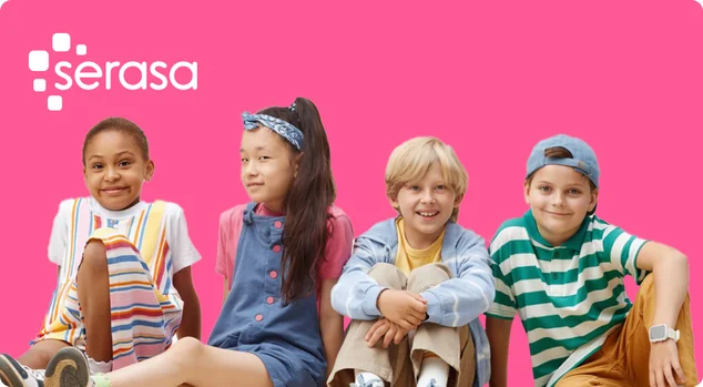 Crianças sorridentes em roupas coloridas sentadas no chão do estúdio contra fundo neutro