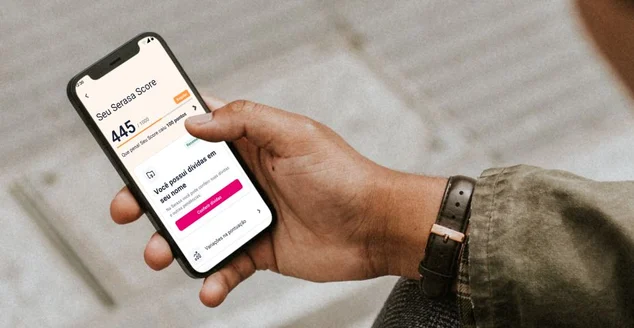 homem segurando um celular com o app da serasa aberto