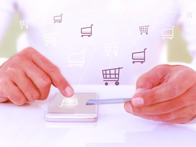 carrinho de compra saindo de um celular e cartao de credito ao lado