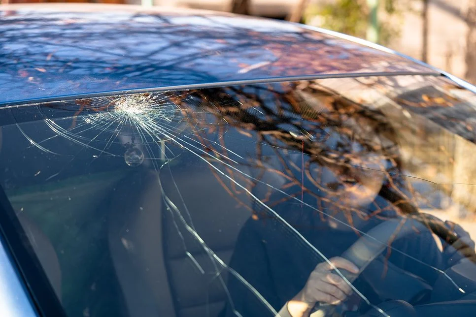 lose-up da peça danificada do carro após o acidente mostrando metal quebrado e arranhões
