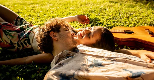 Jovens amigos relaxando na grama do parque em um dia ensolarado