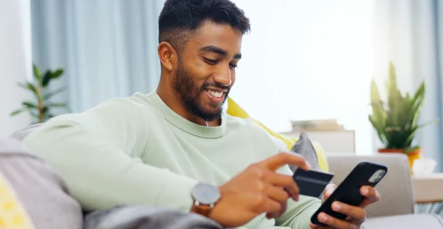 Cartão de crédito, finanças e homem com smartphone para compras on-line no lounge em casa.