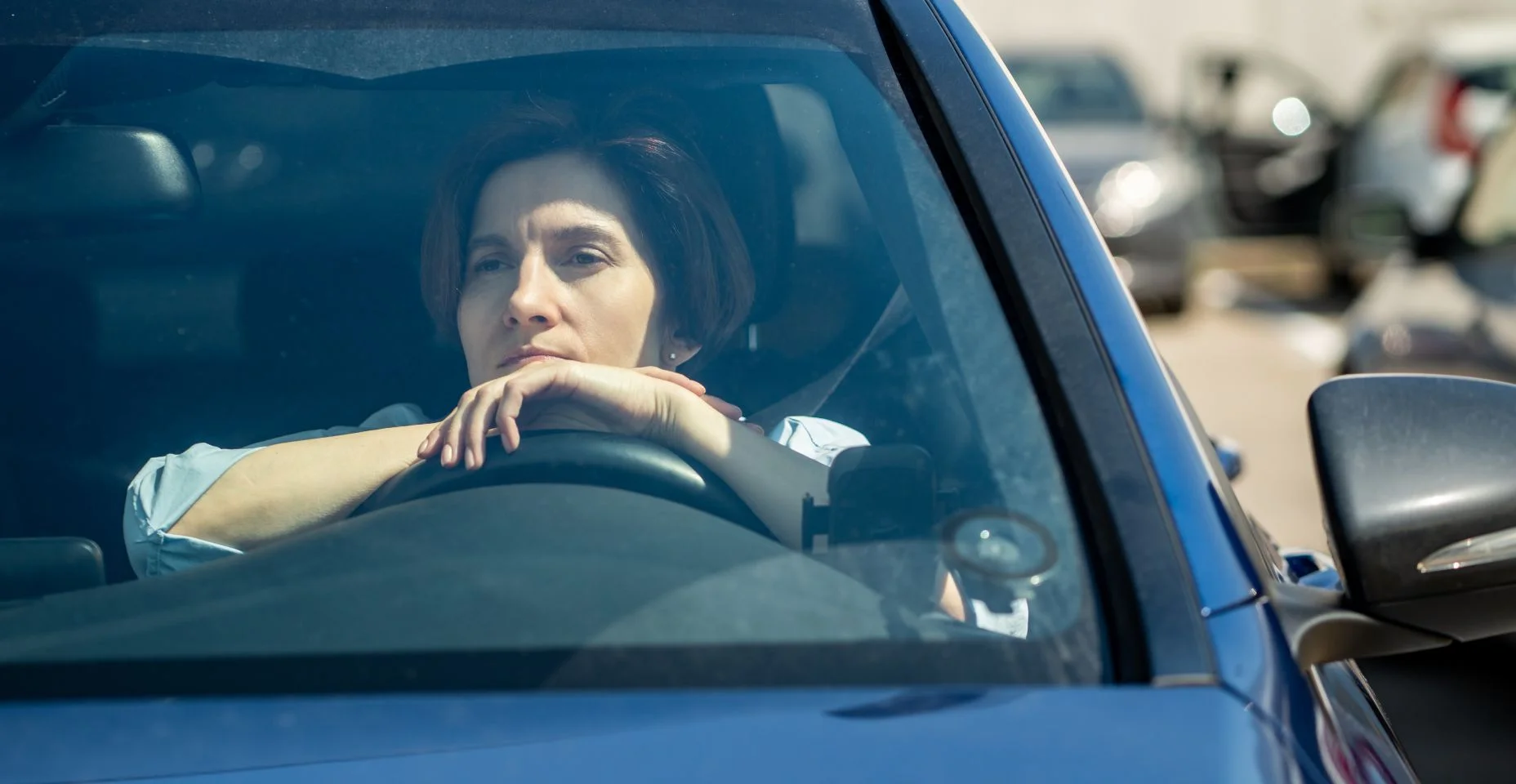 Deprimida, estressada, motorista de meia idade senta-se no carro no estacionamento da cidade