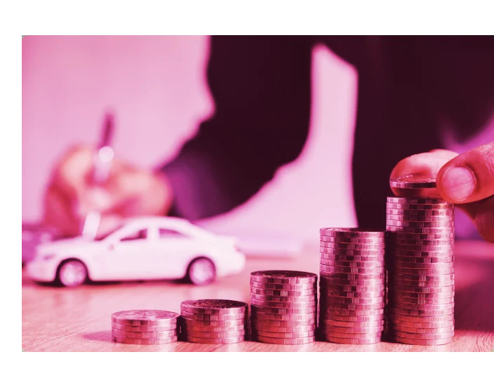 Homem com um mini carro e uma ilustração de uma pilha de moedas para falar um pouco sobre refinanciamento de veículos