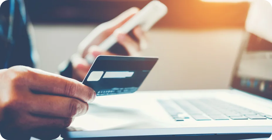 Cartão de crédito de exploração do homem segurando o cartão de crédito e usando telefone celular com compras on-line