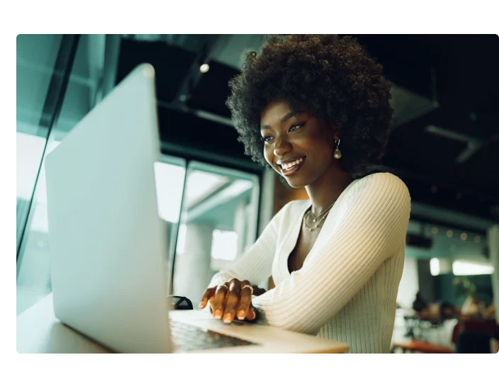 mulher mexendo no computador e rindo