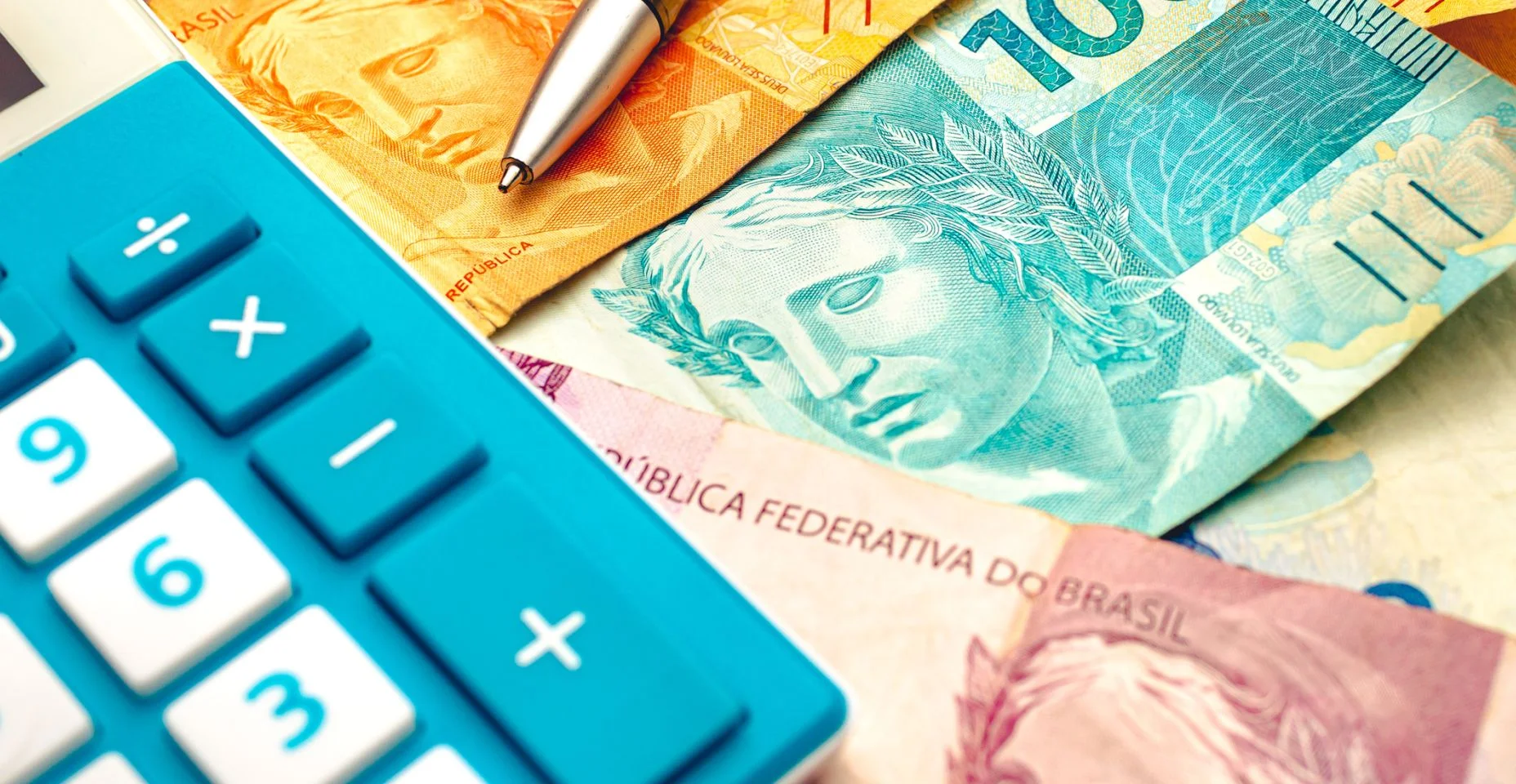 Dinheiro real do Brasil. Notas reais brasileiras em uma mesa de madeira com uma calculadora e caneta na composição. economia e planejamento financeiro