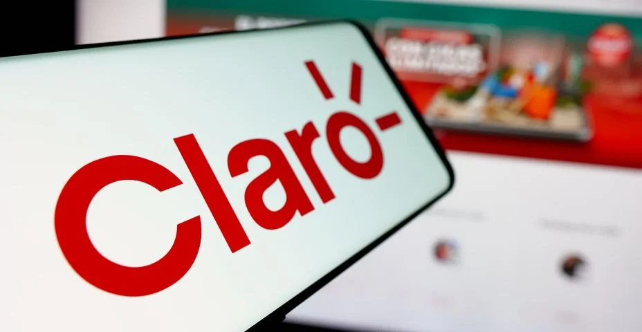 Smartphone com o logotipo da empresa de telecomunicações Claro Equador na tela em frente ao site. Destaque no centro esquerdo da tela do telefone.