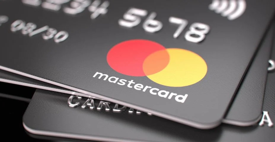 Cartões bancários Mastercard em cima da mesa. Foco no logotipo da Mastercard.