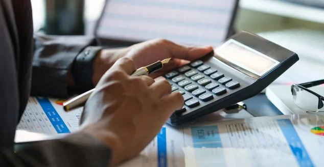Contador focado trabalhando usando calculadora para cálculo de finanças, impostos e estatísticas.