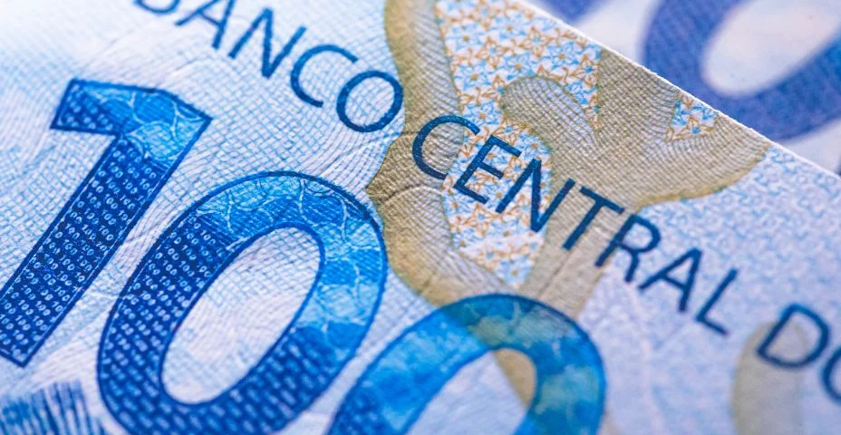 Uma nota de 100 reais vista pelo verso mostrando o texto referente ao Banco Central do Brasil.