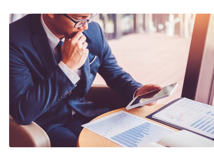 Homem de negócios que trabalha e que usa a tabuleta de Digitas investimento novo do projeto financeiro no café Coffee.