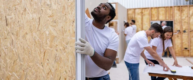 Voluntário instalando uma janela enquanto construía uma casa