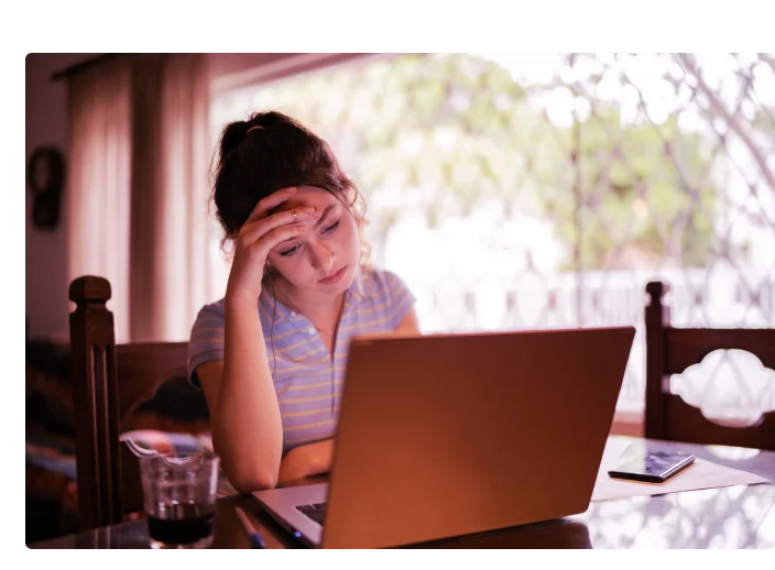 mulher olhando para o computador preocupada