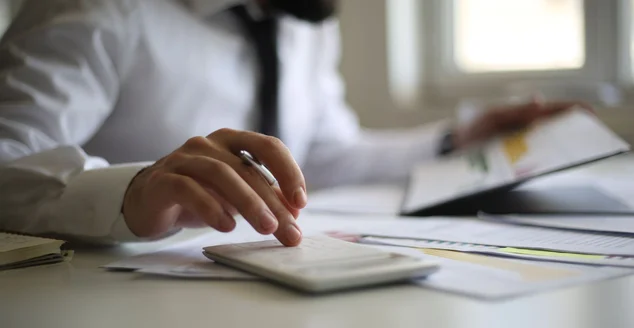 Conceito de contabilidade empresarial, Homem de negócios usando calculadora com laptop de computador, orçamento e papel de empréstimo no escritório.