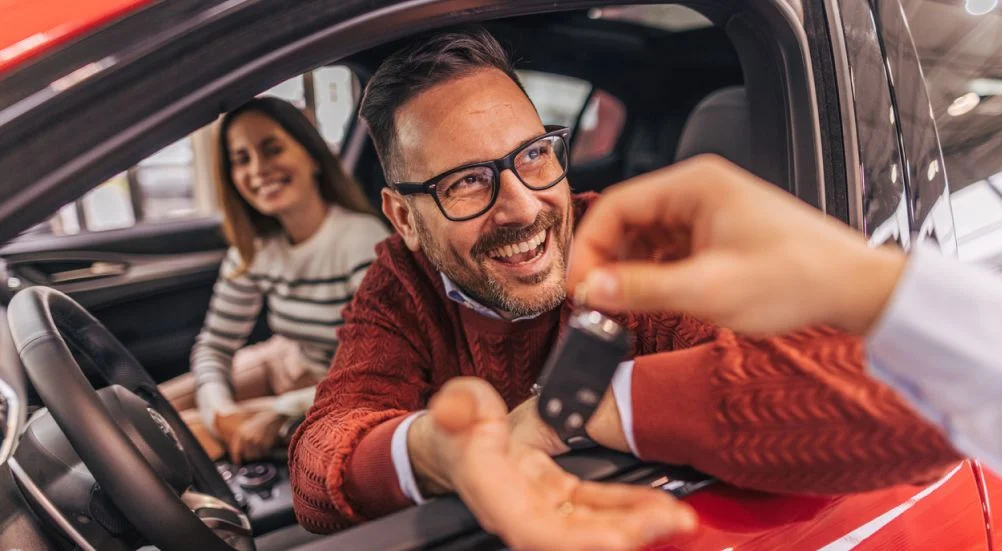 Um, par, sentando, em, um, carro, recebendo, a, chaves, de, um, concessionário de automóveis