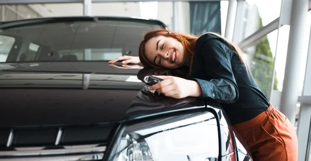 Mulher feliz abraça seu carro novo