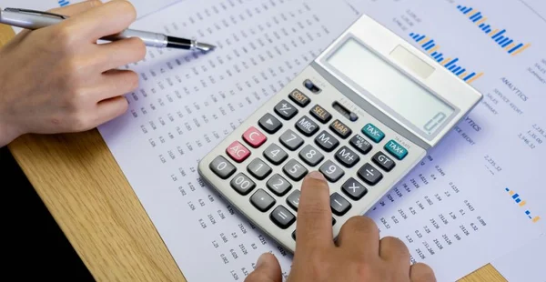 Empresário usando calculadora para calcular o relatório de dados financeiros. Trabalho mensal de planejamento de conta