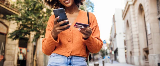 Garota feliz em Barcelona fazendo compras online em movimento