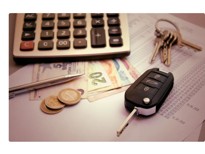 Imagem de um chave encima de conta, com dinheiro ao lado e uma calculadora